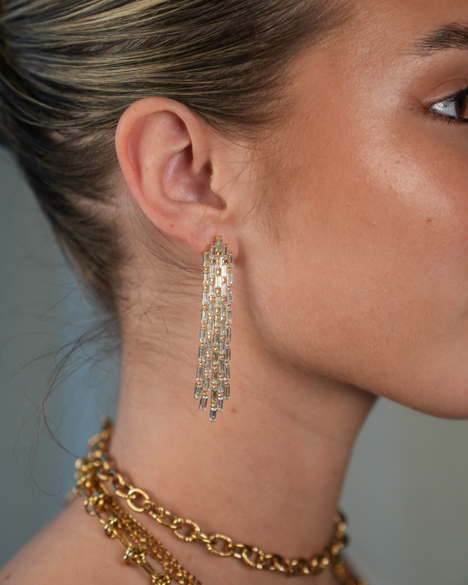 model met lange chique oorbellen in het goudkleurig